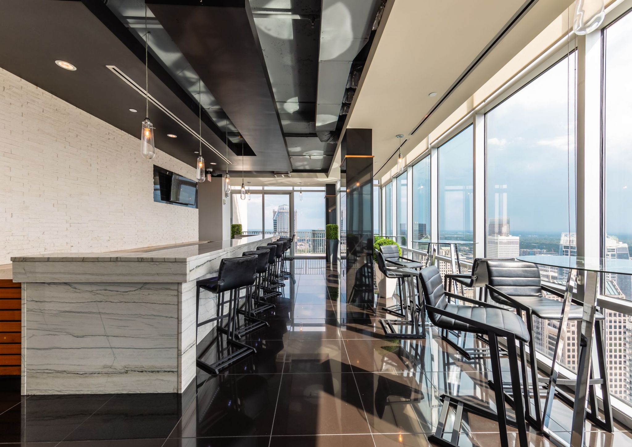 The Vue Charlotte apartments Sky Lounge bar featuring marble countertops, floor-to-ceiling windows and abundant luxury seating