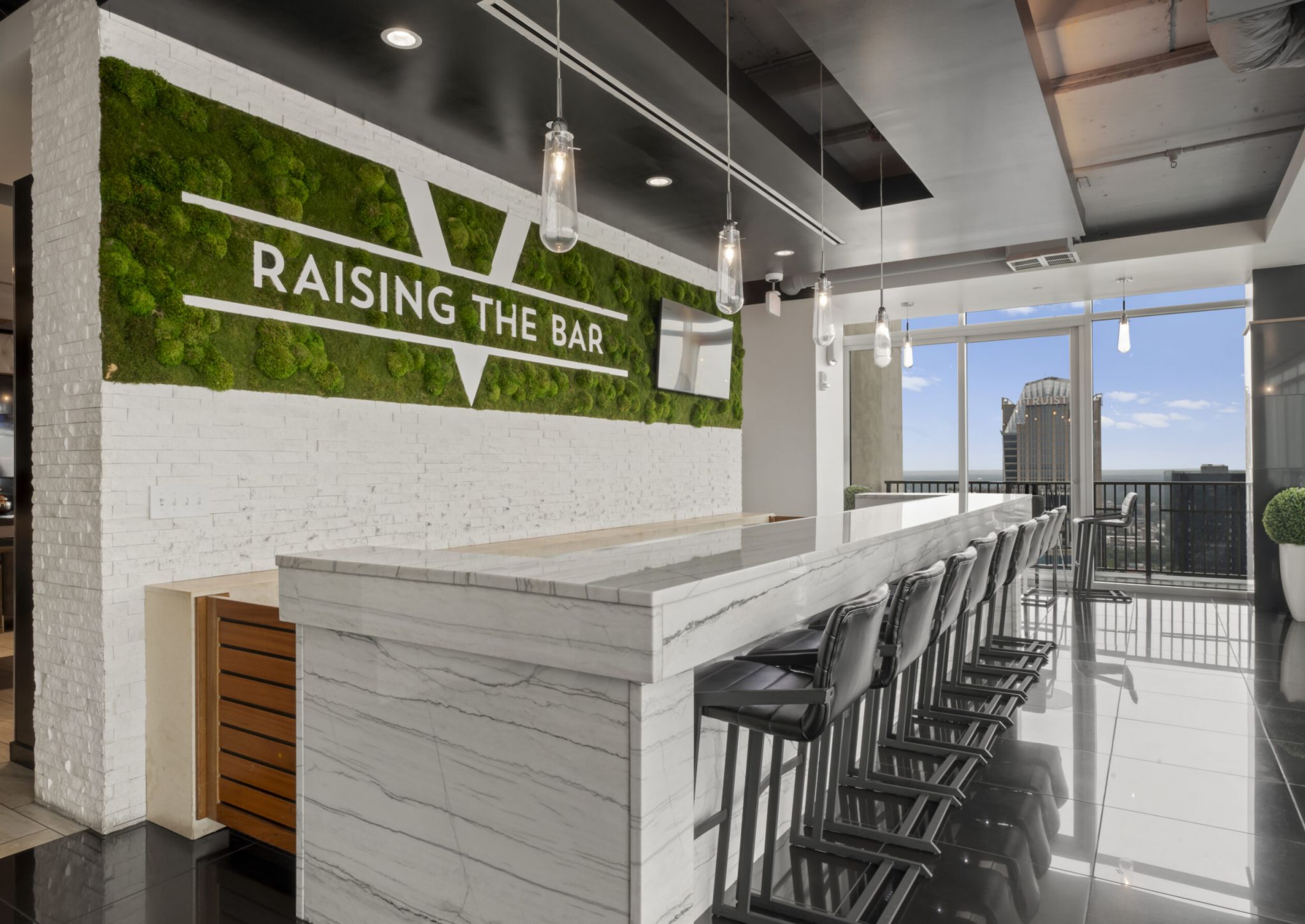 The Vue Charlotte apartments Sky Lounge bar featuring marble countertops, floor-to-ceiling windows and abundant luxury seating
