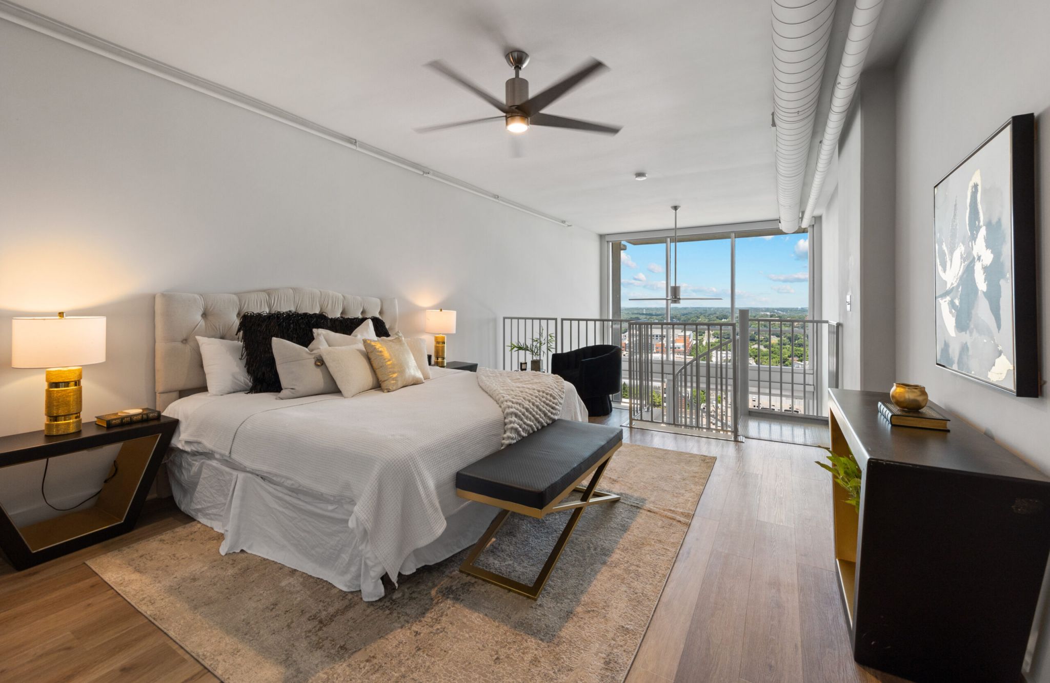 The Vue Charlotte apartment bedroom loft furnished with large bed and ceiling fan
