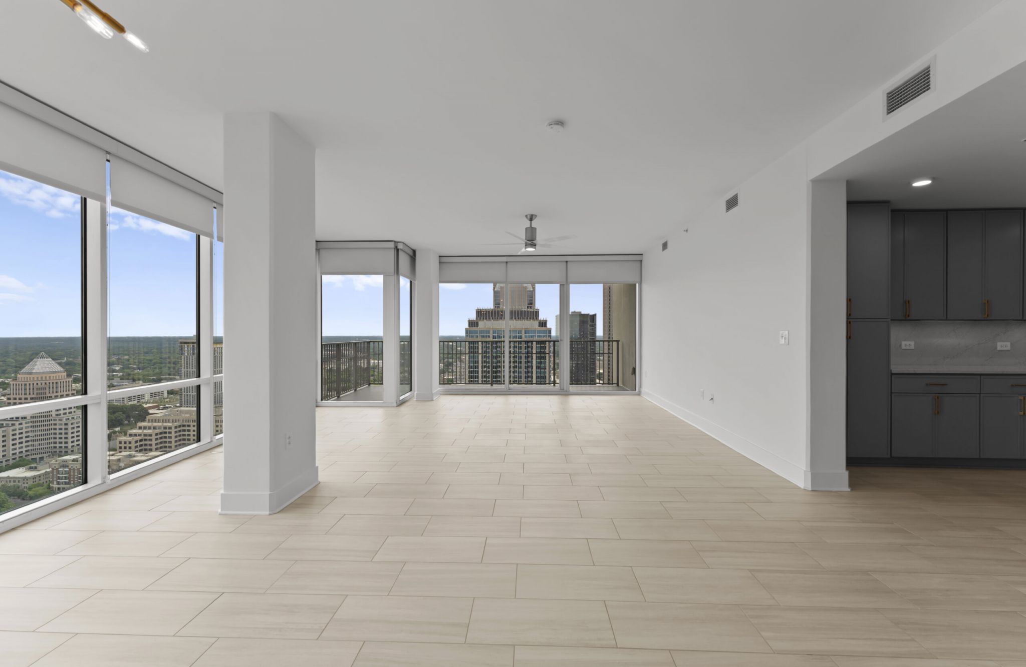 The Vue at Charlotte, NC - beautiful corner unit apartment living and dining area with luxury hard-wood plank flooring, giant full-height windows, and sliding doors