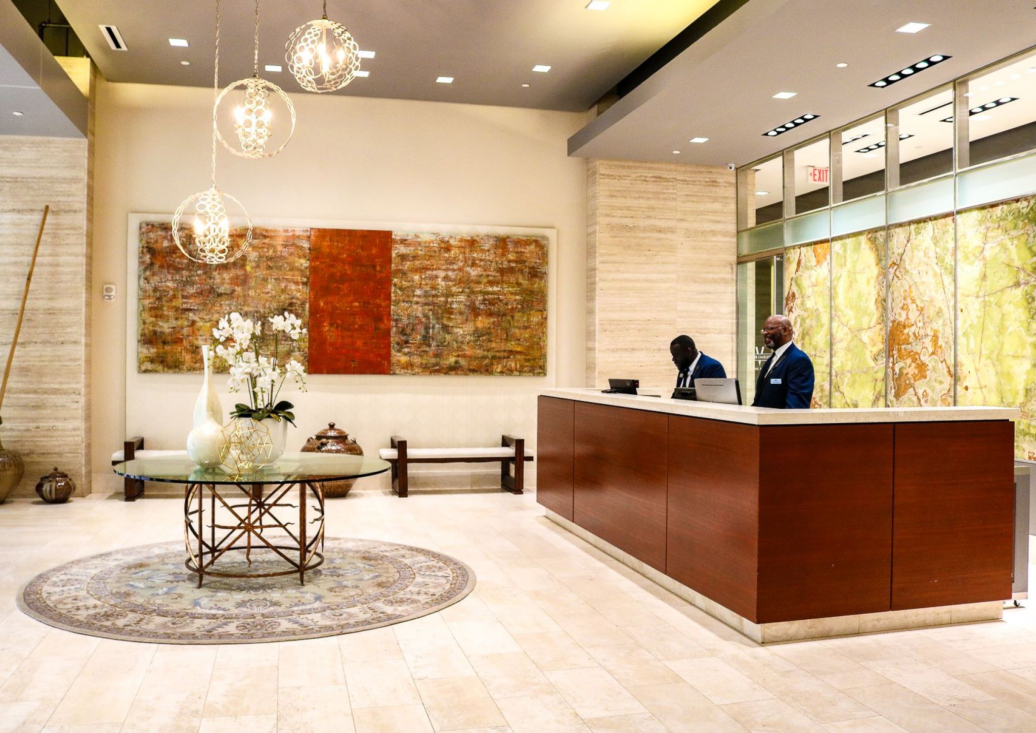 The Vue Charlotte concierge desk with two employees behind a counter in a large beautiful lobby