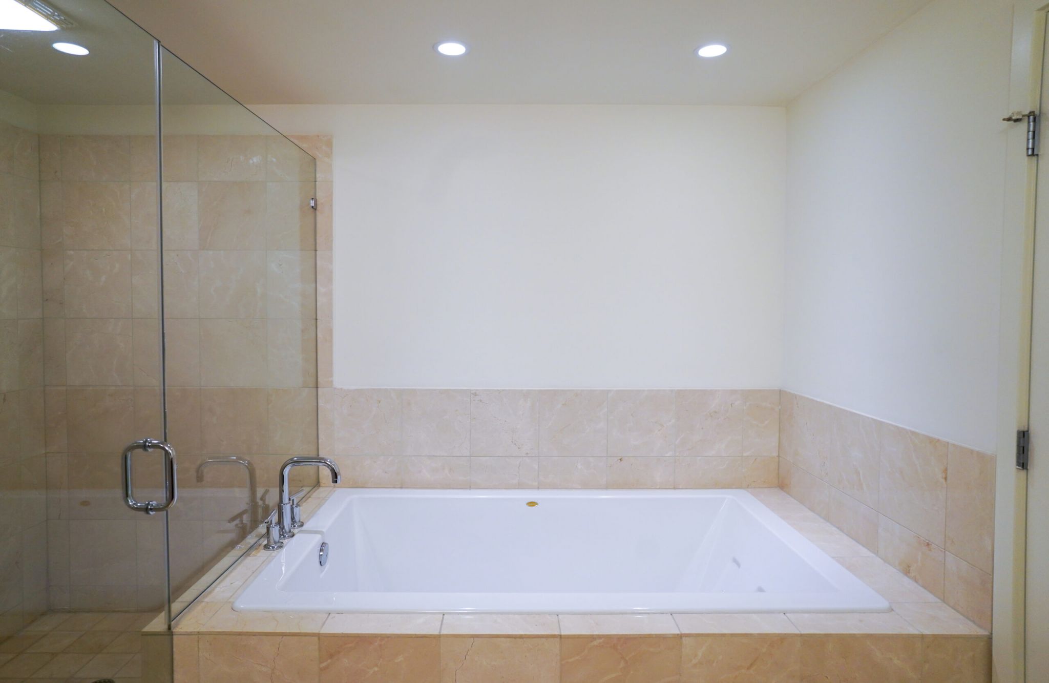 The Vue at Charlotte, NC luxury apartment bathroom with glass-enclosed shower with tile and large soaking tub