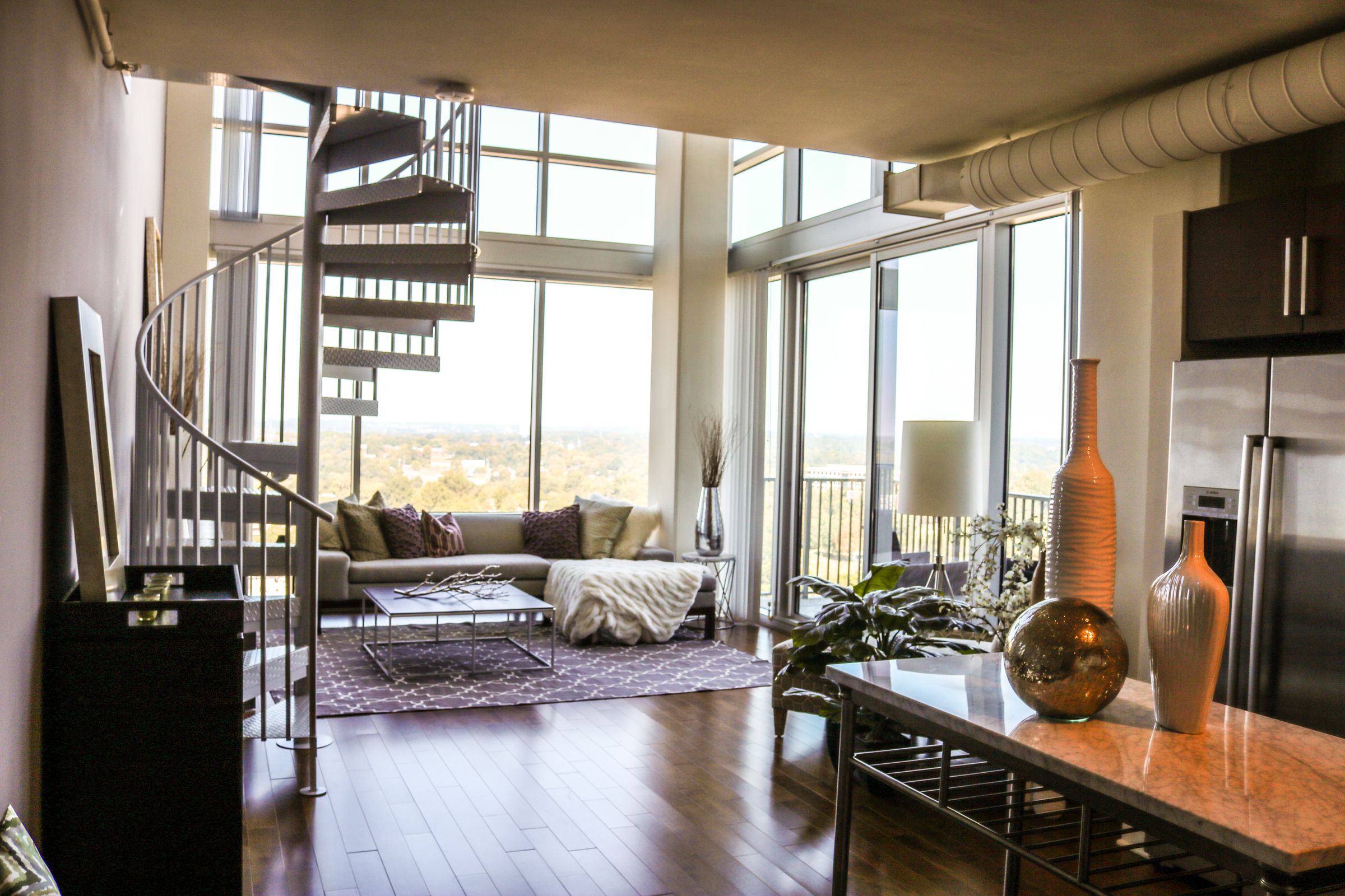 The Vue Charlotte apartment interior with spiral staircase and floor to ceiling windows