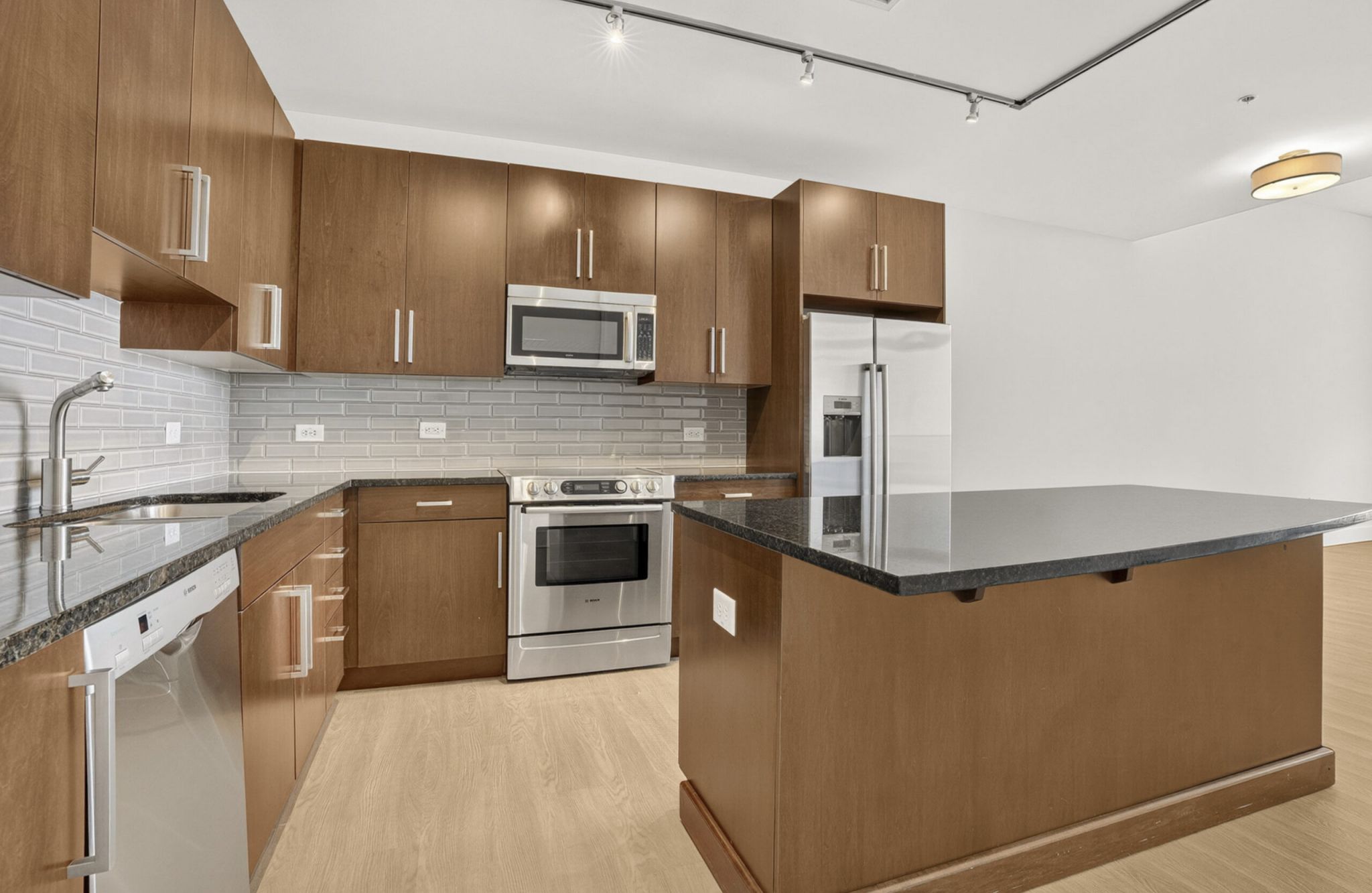 Luxury apartment kitchen with stainless steel appliances, granite countertops, and lots of storage space
